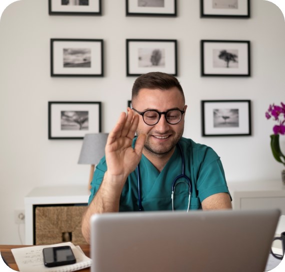 eine Person, die mit den Händen auf dem Gesicht an einem Schreibtisch sitzt